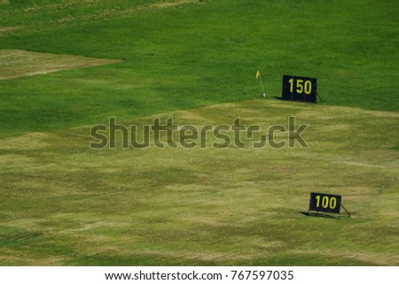 Golf driving range, yard signs and golf balls