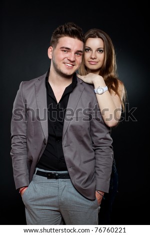 Picture of a happy young boy and girl standing over dark background