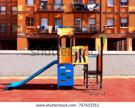 An orange building and an empty playground in Madrid, Spain. 