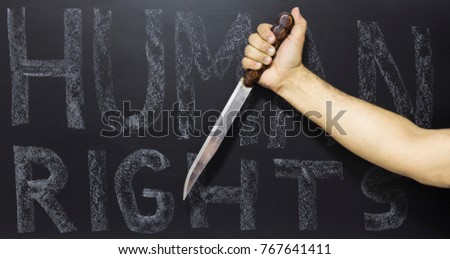Human rights concept: Man holding knife against the text: Human rights day written with chalk on blackboard.