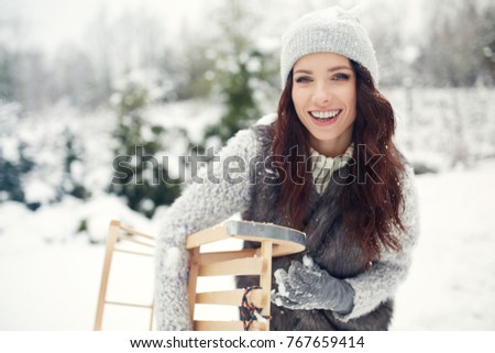 Smiling young woman in wintertime outdoor. girl is having fun. Winter concept