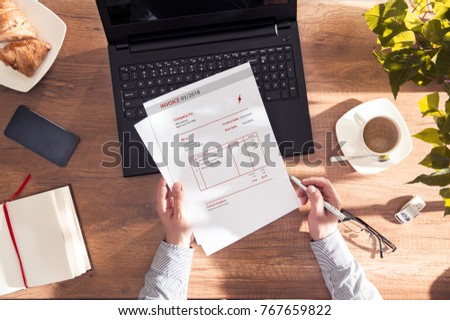 Man reads an invoice for electric power. Document made in graphic program