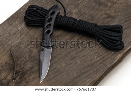 A tourist knife for traveling on a wooden background.