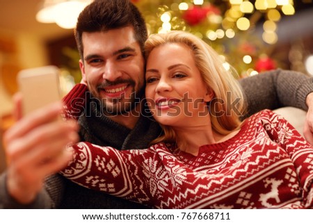 happy couple taking selfie picture with smartphone at home
