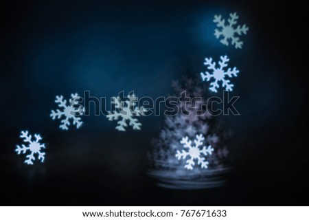 Alternative christmas tree made of snowflakes. Candle and Led lights at night blurred. The picture is unclear.