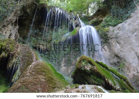 
waterfalls in spring in a deep river, turquoise, clean water with wonderful greenness