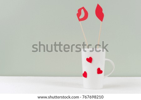 Valentine's day romantic background. Cup with hearts, couple - paper red lips and red lips