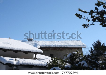 This is a photo of roofs with a lot or snows on top in winter. All the roofs become white. The sky is so clear.