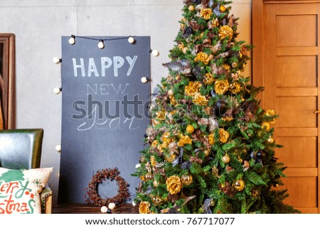 Classic christmas and New Year decorated interior room with presents and New year tree. Christmas tree with gold and black decorations and blackboard