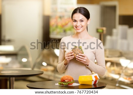 Young woman eating in the supermarket cafeteria