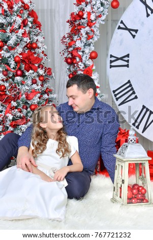 
dad and beautiful daughter in a white dress in New Year's scenery