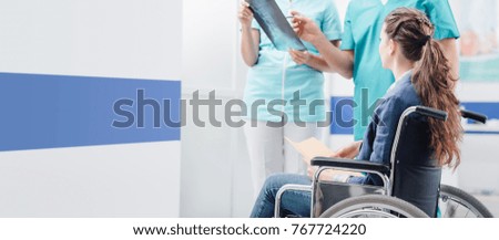 Doctor and nurse examining a disabled patient's x-ray at the hospital, medical consultation and healthcare concept