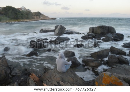 
boy sitting with his back to beautiful landmarks of nature - lakes, oceans, rivers and temples