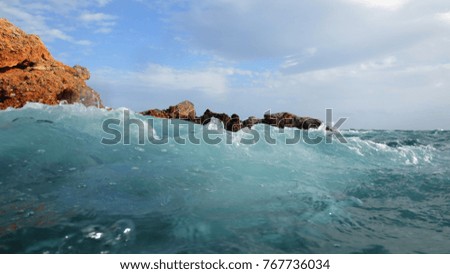 Sea level photo of huge waves reaching tropical volcanic seascape