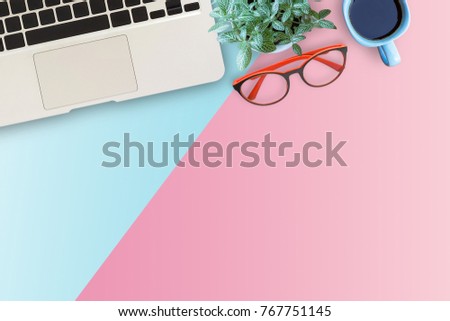 Minimal workspace with Laptop, glasses,flower and smartphone copy space on color background. Top view. Flat lay style.