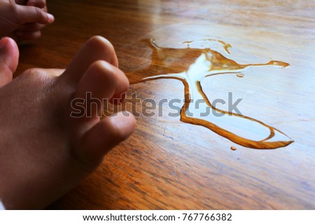 kid drawing picture from dropping water on table