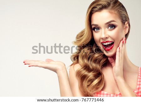 Woman surprise showing product .Beautiful girl  pointing to the side . Presenting your product. Expressive facial expressions emotions Royalty-Free Stock Photo #767771446