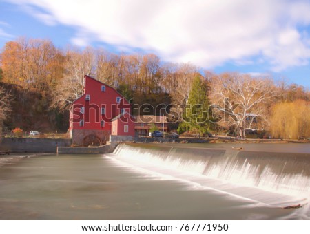 Exterior daytime long exposure stock photo of red barn structure on bank of Raritan river in Clinton, New Jersey in Hunderton County on semi-cloudy fall day