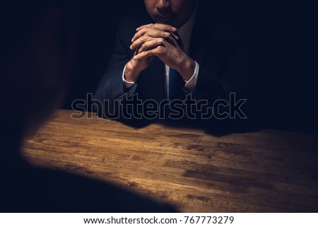 Detective interviewing suspect in dark private room - investigation and interrogation concepts Royalty-Free Stock Photo #767773279