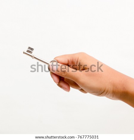 Hand holding the key Isolated on white background. Studio lighting.