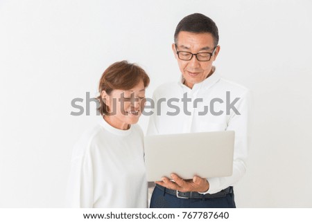 asian senior couple using laptop