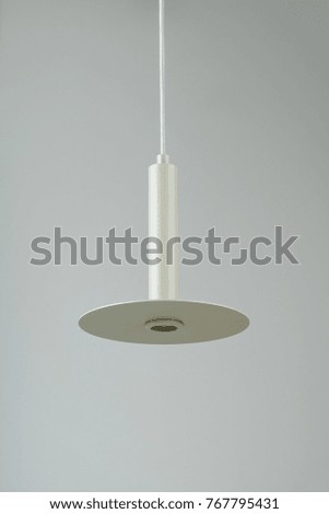 Excellent hanging metallic beige lamp without a light bulb on the gray background indoors. Closeup vertical photo.