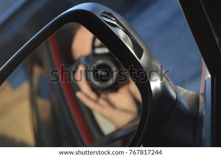 reflection of the photographer in the mirror of the car