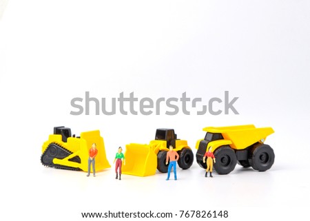 Under construction concept, with group of human toy and heavy duty machinery on white background with copy space for mocup your product.