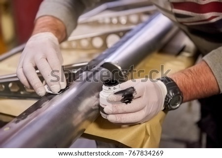 Hand applies primer on steel. Metal detail with coating. Synthetic resin based primer. Royalty-Free Stock Photo #767834269
