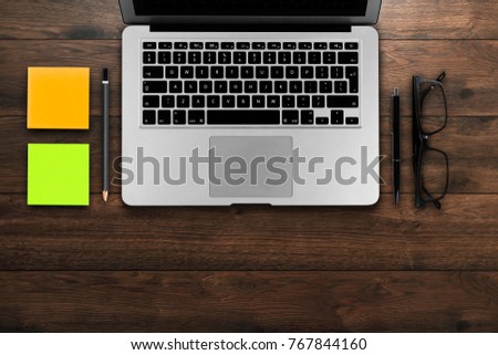 Rustik, worker, wooden table top view, flat. Business items on the table, laptop, phone, pens, stickers. Concept of business attributes. Copy Space.