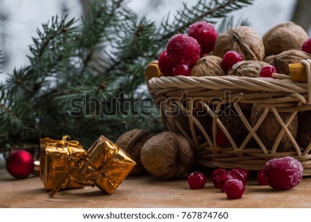 small Christmas golden gifts with a basket of nuts and berries with branches of Christmas tree on the street