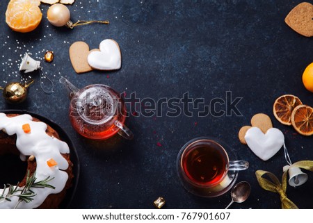 Teatime with heart-shaped ginger cookies, traditional fruitbread and tangerines. Christmas background with festive decoration. Horizontal composition
