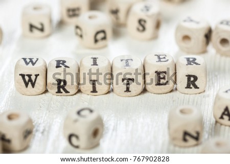 Word WRITER formed by wood alphabet blocks. On old wooden table.