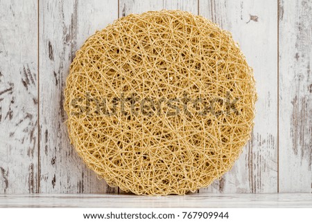Round American style yellow, golden table mat on white wooden background