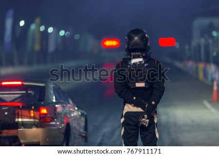 Portrait of a dragster driver with drag car in race track at night. Royalty-Free Stock Photo #767911171