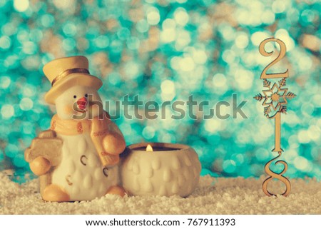 Christmas greeting card, statuette of a Snowman. 2018 the numbers in a column. The snow drifts. Tinted effect.