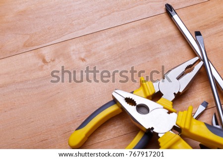 The tools lie in the heap are shown not completely on a wooden background. Top view of a closeup