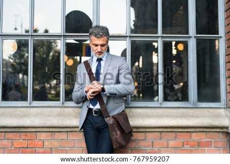 Mature businessman standing in a city.