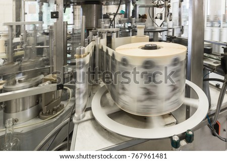 Automatic labeling machine during operation. Factory for the production of alcoholic beverages. Royalty-Free Stock Photo #767961481