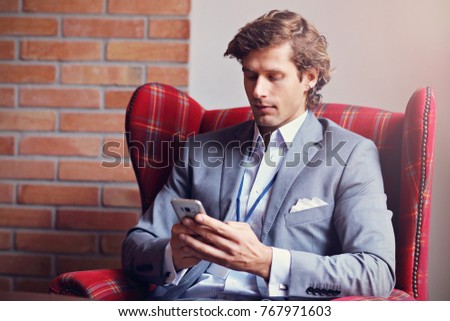 Picture showing young businessman texting on a smartphone