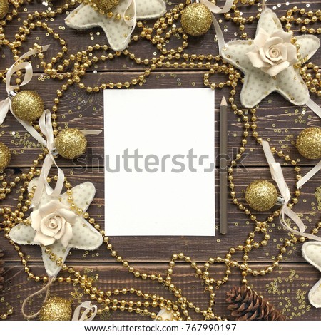 A sheet of paper and pencil on a wooden background with decorations