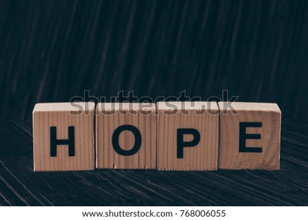 wooden cubes with word Hope on black table