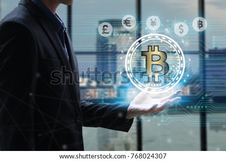Businessman hand holding global network using Currencies sign symbol interface of Bitcoin Fintech, virtual currency blockchain technology concept, Investment Financial Technology Concept.