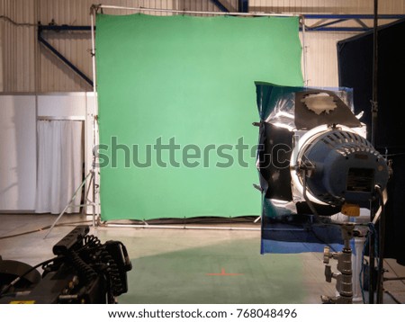 Real empty green screen (Chroma key) film/photo studio with lighting/studio equipment