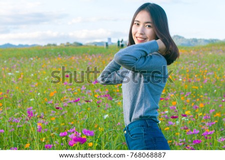 A woman standing in the middle of the flower fields.