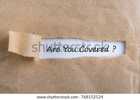 ARE YOU COVERED? Question message appearing behind ripped brown paper. Are you insured for your car, travel, home, health or other liability