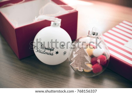 Christmas ball for Christmas festival decoration with opened present box on wooden table. Soft color filter picture tone 
