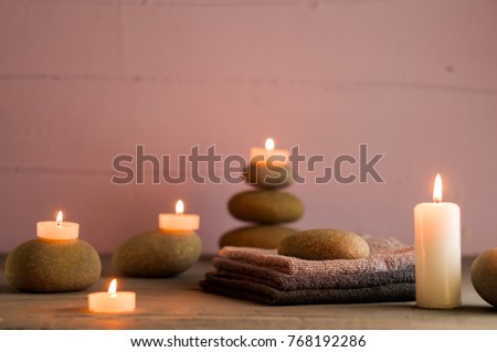 
Candles, sea stones and towels, lilac background