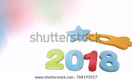 Very soft, bright shot (to give comfort feeling) of magnetic alphabets '2018' below little rocket and star in white background. On top is soft color shade in sweet pastel tone.  
