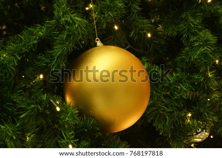 Abstract Christmas gold bokeh lights with golden ball decoration on Christmas tree background. place for text concept. Beautiful Festive textured background.